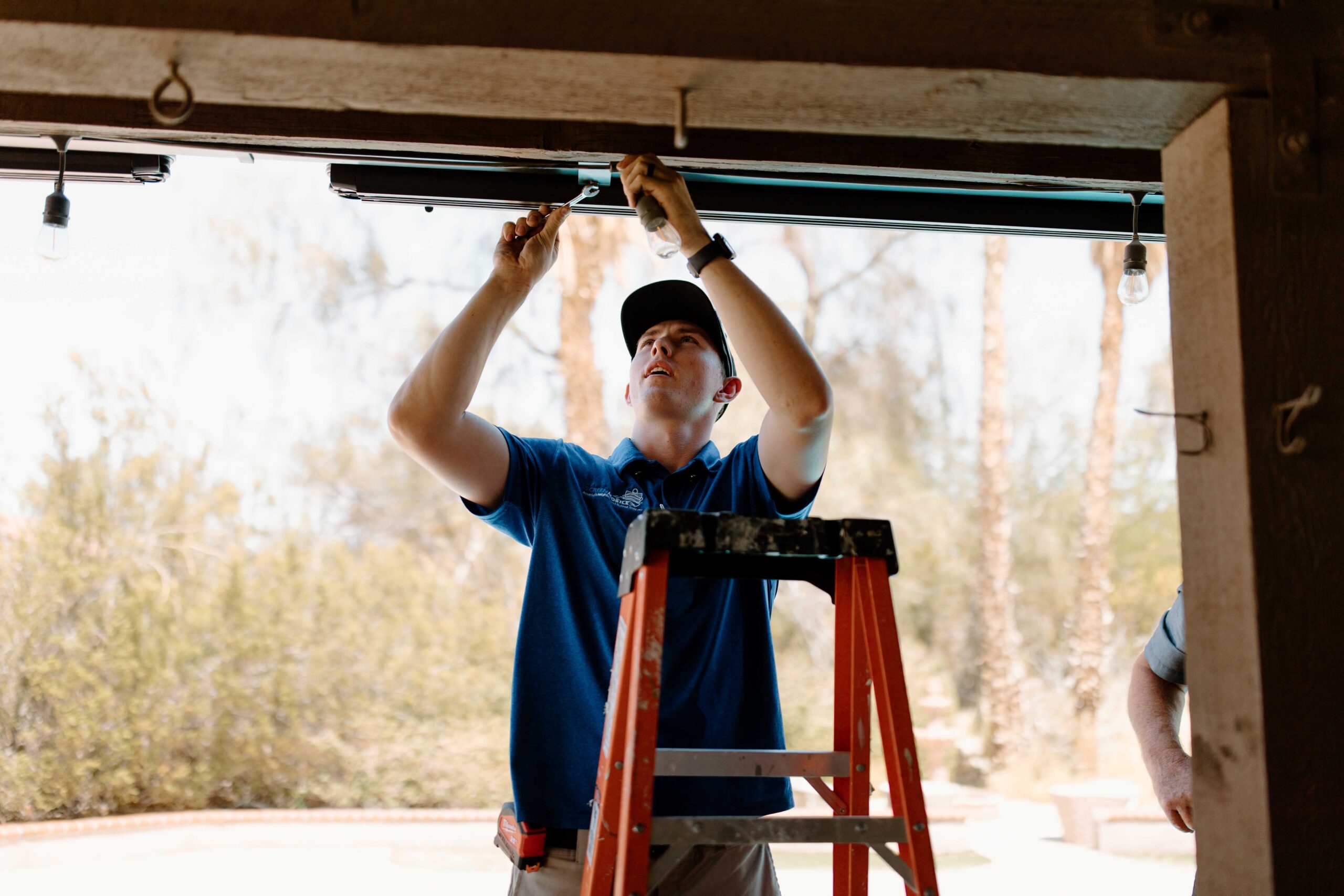 Screenmobile franchise owner installing outdoor screen on house